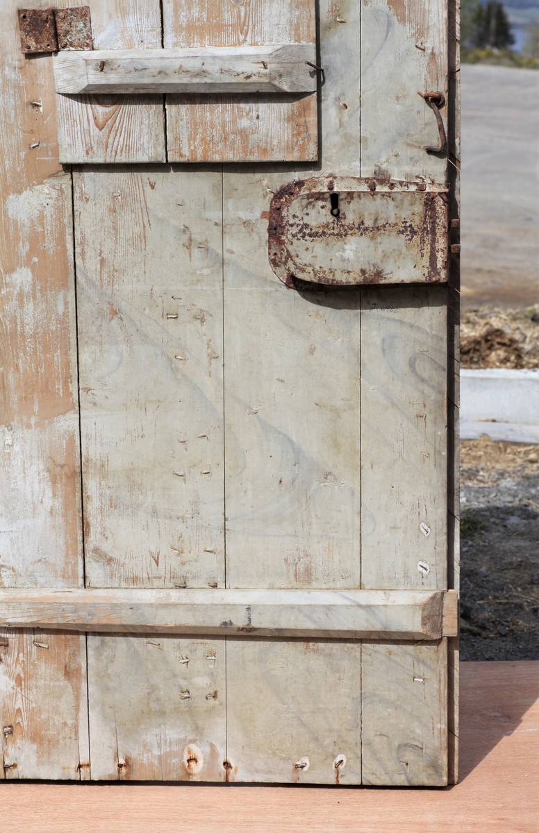 Døra er laget av 1 1/4 toms planker med to enkle drev som holder plankene sammen. Døra er belagt med profilert panel. Panelet er lagt på skrå i mønemønster og festet med spiker som har digre hoder. Døra har et vindu på 45 cm x 79 cm som innvendig er lukket med en liten hengslet dør. Døra er nærmest halvsirkelformet i toppen og passer da inn i buen i murverket. Låsen sitter på og har rombeformet nøkkelhullbeslag og to solide gangjern med to enkle knuter. Låsen sitter på innsida og er helt innebygd med jernplater og to slåtter. På innsida er rester etter påmalt marmorering.