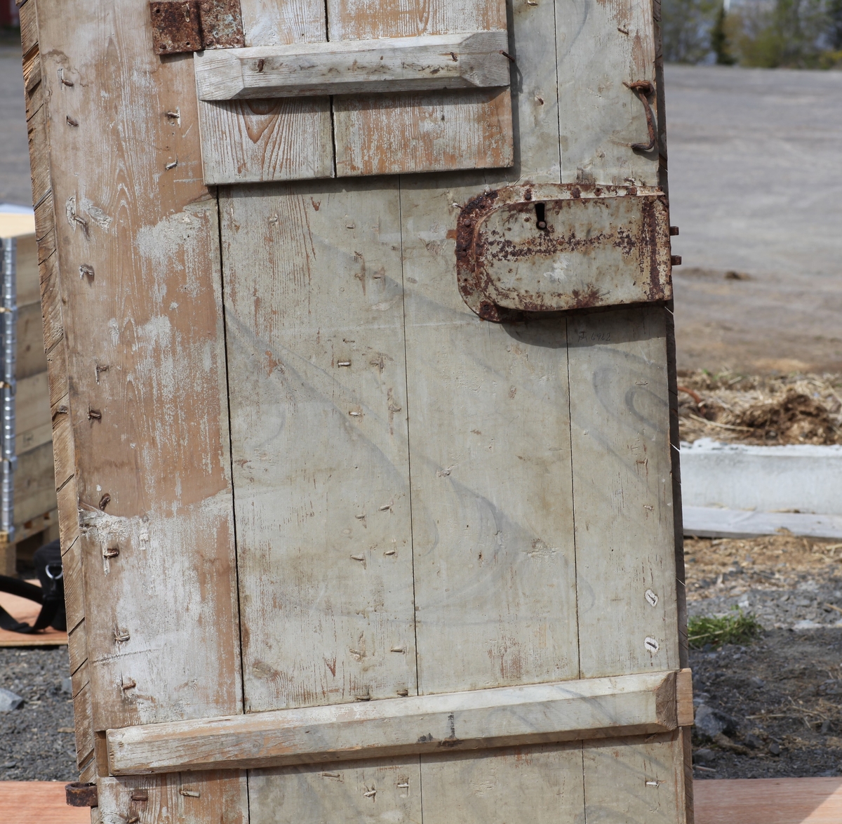 Døra er laget av 1 1/4 toms planker med to enkle drev som holder plankene sammen. Døra er belagt med profilert panel. Panelet er lagt på skrå i mønemønster og festet med spiker som har digre hoder. Døra har et vindu på 45 cm x 79 cm som innvendig er lukket med en liten hengslet dør. Døra er nærmest halvsirkelformet i toppen og passer da inn i buen i murverket. Låsen sitter på og har rombeformet nøkkelhullbeslag og to solide gangjern med to enkle knuter. Låsen sitter på innsida og er helt innebygd med jernplater og to slåtter. På innsida er rester etter påmalt marmorering.