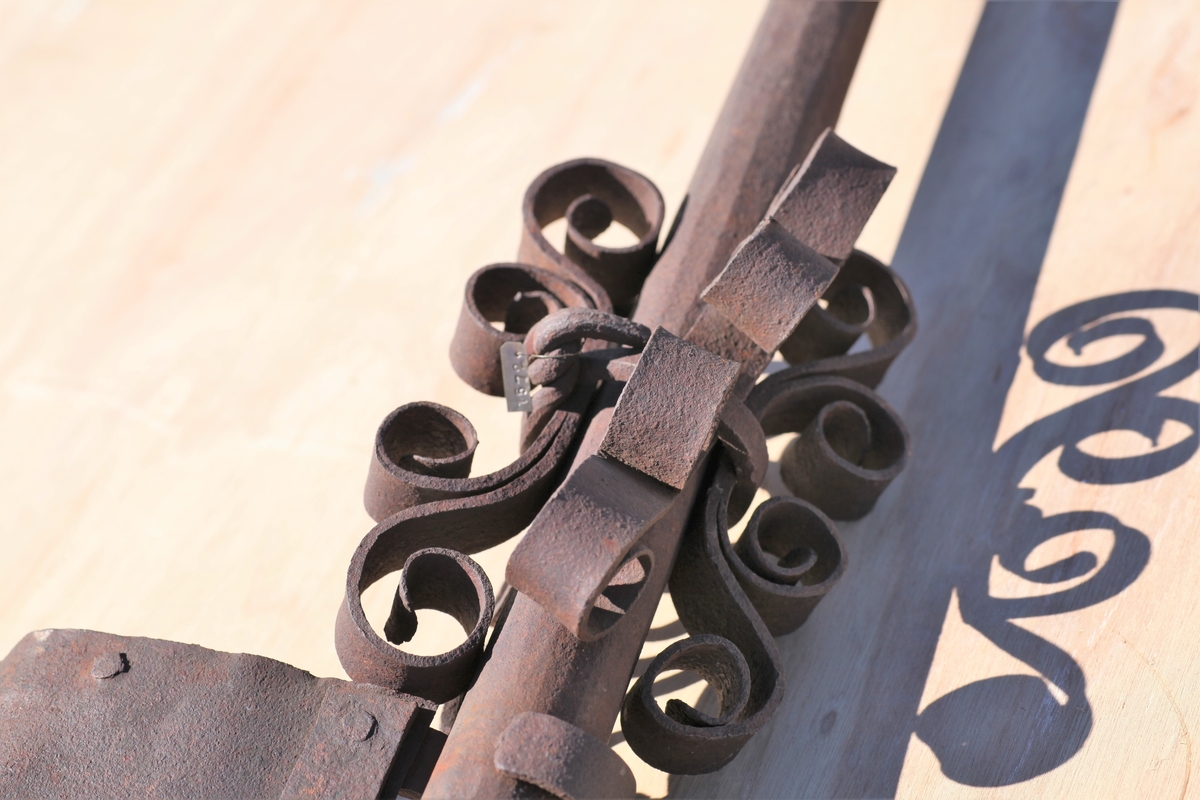 Øverste del av et spir som har stått på Aas kirke tidligere. Jernstang med værhane.