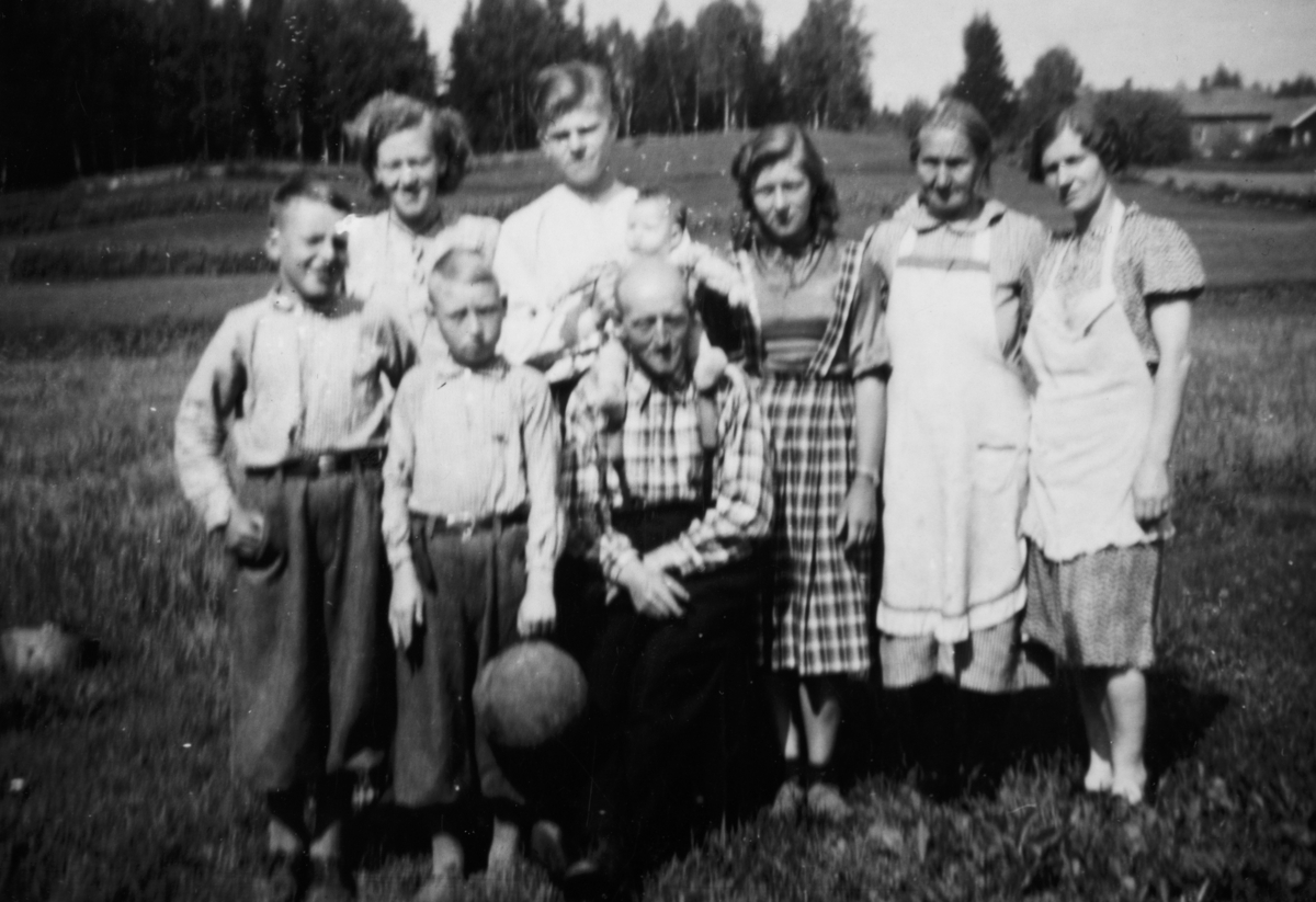 Granheim av Store Oppsal.  Foran står Oddvar og Oddvar. Laurits sitter med Signe Karin på skuldra. Karen, ukjent, Olga, Laura og Grete.