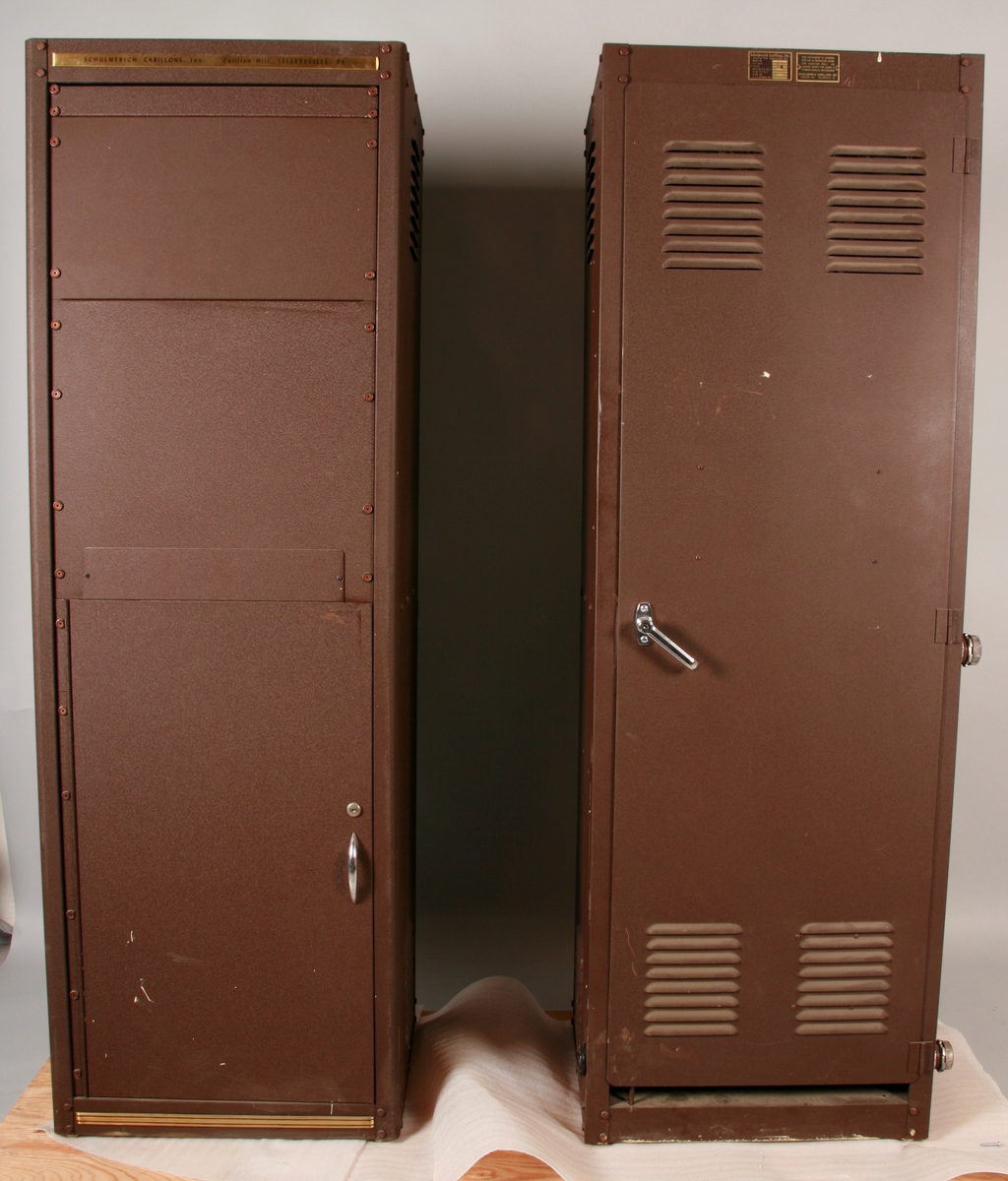 To brunmalte skap i metall (samme størrelse). Flere ventilasjonsrister.

Det ene skapet (A) inneholder avspiller, forsterker, klokkemekanikk, liten høytaler og øvrig elektronikk (noen deler ser ut å mangle). 
Øvre halvdel: bak pleksiglass som kan lukkes er styresentralen med instillinger for ulike klokkeprogrammer:
Til høyre er switch-knapper for å aktivere de tre funksjonene 
a) avspilling av musikkrull 
b) bruk av manuelt spillebord og 
c) timeslag.

Over til venstre er en timer for å skjemalegge de ulike aktivitetene:
1) Hverdag avspilling musikkrull
2) Søndag avspilling musikkrull
3) Hverdag avspilling timeslag
4) Søndag avspilling timeslag
5) Hverdag avspilling manuelt spillebord
6) Søndag avspilling manuelt spillebord

I tillegg er et eget panel for å velge ulike fomer av klokkeringinger ('BELL PEAL').

Nedre halvdel: Musikkrullmekanikk med en mekanisk avleser for musikkrullene ('tracker bar'). 30 spor; én for én tone hver. Papirullen løper over en rekke fjærbelastede(?) L-formet tangenter, en for hvert spor. Når et hull passerer en tangent løftes tangenten oppover og gir i sin tur et signal videre om å aktivere akkurat denne tonen.

Det andre skapet (B) idag tomt, usikker funksjon. Har strømforsyning. Sannsynlig forsterker for bruk av høytalere (C-F) i klokketårnet. Se elektronikk (H). Muligens også oppbevaring av musikkruller med mer.