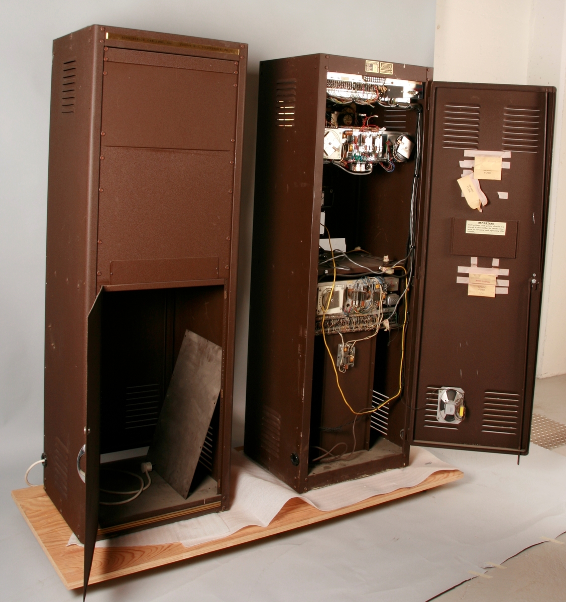 To brunmalte skap i metall (samme størrelse). Flere ventilasjonsrister.

Det ene skapet (A) inneholder avspiller, forsterker, klokkemekanikk, liten høytaler og øvrig elektronikk (noen deler ser ut å mangle). 
Øvre halvdel: bak pleksiglass som kan lukkes er styresentralen med instillinger for ulike klokkeprogrammer:
Til høyre er switch-knapper for å aktivere de tre funksjonene 
a) avspilling av musikkrull 
b) bruk av manuelt spillebord og 
c) timeslag.

Over til venstre er en timer for å skjemalegge de ulike aktivitetene:
1) Hverdag avspilling musikkrull
2) Søndag avspilling musikkrull
3) Hverdag avspilling timeslag
4) Søndag avspilling timeslag
5) Hverdag avspilling manuelt spillebord
6) Søndag avspilling manuelt spillebord

I tillegg er et eget panel for å velge ulike fomer av klokkeringinger ('BELL PEAL').

Nedre halvdel: Musikkrullmekanikk med en mekanisk avleser for musikkrullene ('tracker bar'). 30 spor; én for én tone hver. Papirullen løper over en rekke fjærbelastede(?) L-formet tangenter, en for hvert spor. Når et hull passerer en tangent løftes tangenten oppover og gir i sin tur et signal videre om å aktivere akkurat denne tonen.

Det andre skapet (B) idag tomt, usikker funksjon. Har strømforsyning. Sannsynlig forsterker for bruk av høytalere (C-F) i klokketårnet. Se elektronikk (H). Muligens også oppbevaring av musikkruller med mer.