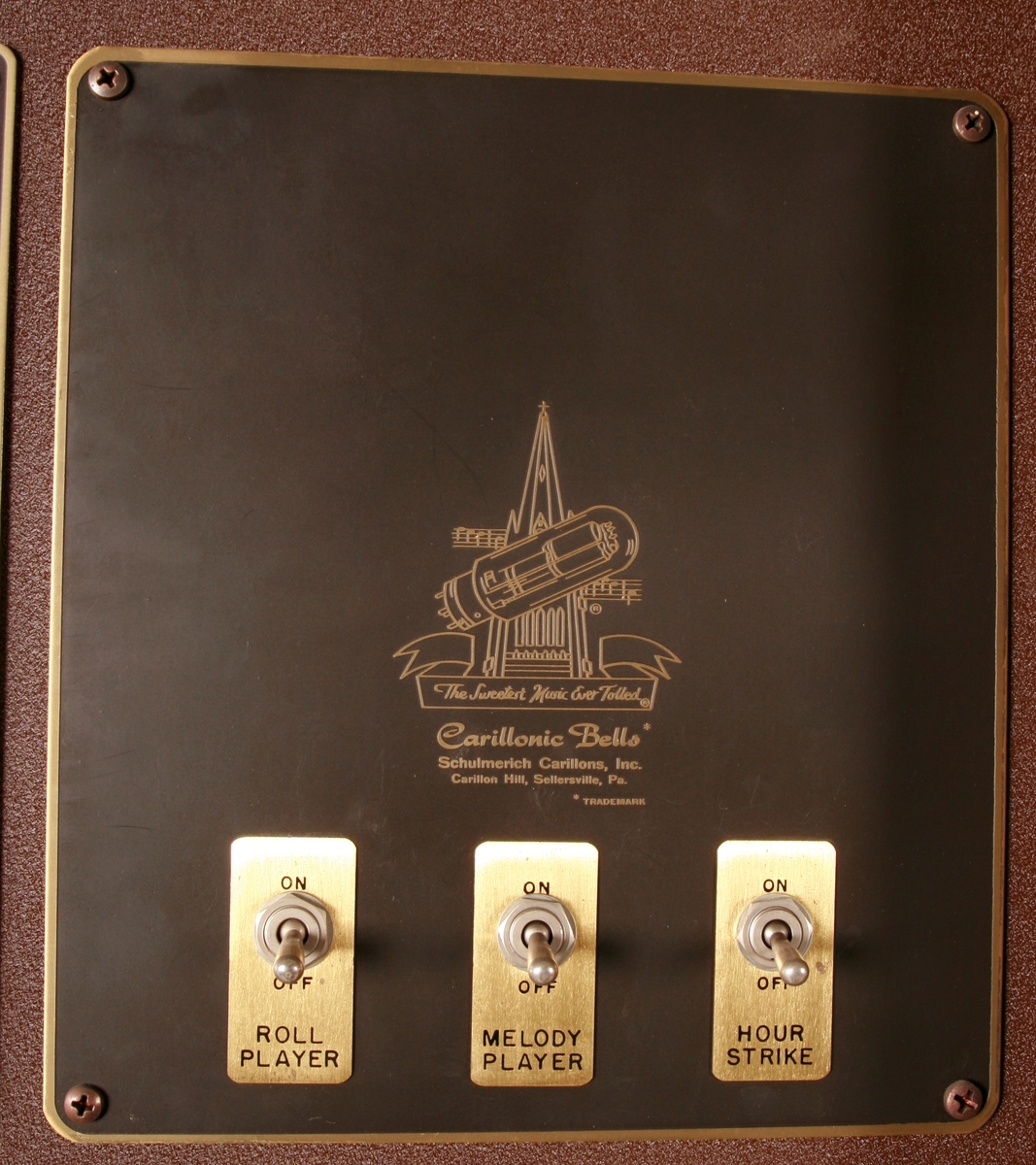 To brunmalte skap i metall (samme størrelse). Flere ventilasjonsrister.

Det ene skapet (A) inneholder avspiller, forsterker, klokkemekanikk, liten høytaler og øvrig elektronikk (noen deler ser ut å mangle). 
Øvre halvdel: bak pleksiglass som kan lukkes er styresentralen med instillinger for ulike klokkeprogrammer:
Til høyre er switch-knapper for å aktivere de tre funksjonene 
a) avspilling av musikkrull 
b) bruk av manuelt spillebord og 
c) timeslag.

Over til venstre er en timer for å skjemalegge de ulike aktivitetene:
1) Hverdag avspilling musikkrull
2) Søndag avspilling musikkrull
3) Hverdag avspilling timeslag
4) Søndag avspilling timeslag
5) Hverdag avspilling manuelt spillebord
6) Søndag avspilling manuelt spillebord

I tillegg er et eget panel for å velge ulike fomer av klokkeringinger ('BELL PEAL').

Nedre halvdel: Musikkrullmekanikk med en mekanisk avleser for musikkrullene ('tracker bar'). 30 spor; én for én tone hver. Papirullen løper over en rekke fjærbelastede(?) L-formet tangenter, en for hvert spor. Når et hull passerer en tangent løftes tangenten oppover og gir i sin tur et signal videre om å aktivere akkurat denne tonen.

Det andre skapet (B) idag tomt, usikker funksjon. Har strømforsyning. Sannsynlig forsterker for bruk av høytalere (C-F) i klokketårnet. Se elektronikk (H). Muligens også oppbevaring av musikkruller med mer.