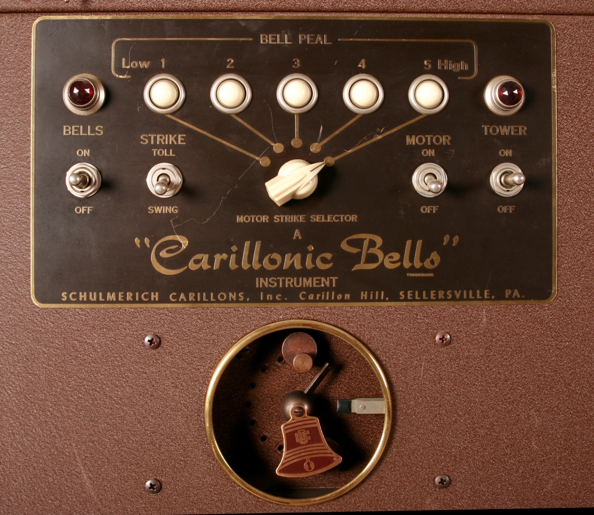 To brunmalte skap i metall (samme størrelse). Flere ventilasjonsrister.

Det ene skapet (A) inneholder avspiller, forsterker, klokkemekanikk, liten høytaler og øvrig elektronikk (noen deler ser ut å mangle). 
Øvre halvdel: bak pleksiglass som kan lukkes er styresentralen med instillinger for ulike klokkeprogrammer:
Til høyre er switch-knapper for å aktivere de tre funksjonene 
a) avspilling av musikkrull 
b) bruk av manuelt spillebord og 
c) timeslag.

Over til venstre er en timer for å skjemalegge de ulike aktivitetene:
1) Hverdag avspilling musikkrull
2) Søndag avspilling musikkrull
3) Hverdag avspilling timeslag
4) Søndag avspilling timeslag
5) Hverdag avspilling manuelt spillebord
6) Søndag avspilling manuelt spillebord

I tillegg er et eget panel for å velge ulike fomer av klokkeringinger ('BELL PEAL').

Nedre halvdel: Musikkrullmekanikk med en mekanisk avleser for musikkrullene ('tracker bar'). 30 spor; én for én tone hver. Papirullen løper over en rekke fjærbelastede(?) L-formet tangenter, en for hvert spor. Når et hull passerer en tangent løftes tangenten oppover og gir i sin tur et signal videre om å aktivere akkurat denne tonen.

Det andre skapet (B) idag tomt, usikker funksjon. Har strømforsyning. Sannsynlig forsterker for bruk av høytalere (C-F) i klokketårnet. Se elektronikk (H). Muligens også oppbevaring av musikkruller med mer.