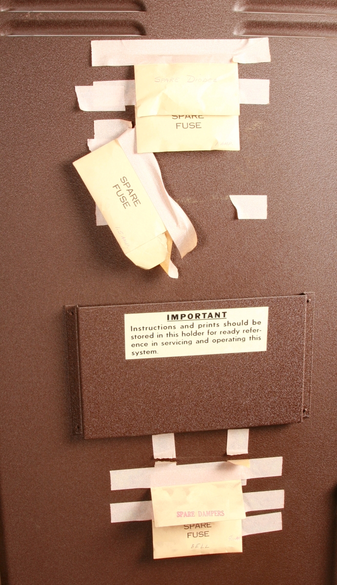 To brunmalte skap i metall (samme størrelse). Flere ventilasjonsrister.

Det ene skapet (A) inneholder avspiller, forsterker, klokkemekanikk, liten høytaler og øvrig elektronikk (noen deler ser ut å mangle). 
Øvre halvdel: bak pleksiglass som kan lukkes er styresentralen med instillinger for ulike klokkeprogrammer:
Til høyre er switch-knapper for å aktivere de tre funksjonene 
a) avspilling av musikkrull 
b) bruk av manuelt spillebord og 
c) timeslag.

Over til venstre er en timer for å skjemalegge de ulike aktivitetene:
1) Hverdag avspilling musikkrull
2) Søndag avspilling musikkrull
3) Hverdag avspilling timeslag
4) Søndag avspilling timeslag
5) Hverdag avspilling manuelt spillebord
6) Søndag avspilling manuelt spillebord

I tillegg er et eget panel for å velge ulike fomer av klokkeringinger ('BELL PEAL').

Nedre halvdel: Musikkrullmekanikk med en mekanisk avleser for musikkrullene ('tracker bar'). 30 spor; én for én tone hver. Papirullen løper over en rekke fjærbelastede(?) L-formet tangenter, en for hvert spor. Når et hull passerer en tangent løftes tangenten oppover og gir i sin tur et signal videre om å aktivere akkurat denne tonen.

Det andre skapet (B) idag tomt, usikker funksjon. Har strømforsyning. Sannsynlig forsterker for bruk av høytalere (C-F) i klokketårnet. Se elektronikk (H). Muligens også oppbevaring av musikkruller med mer.