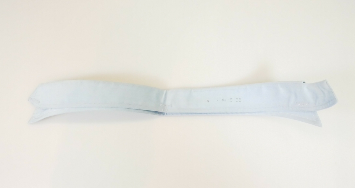 Blå løskrage i bomull til herredrakt. Kragen er brettet. Den innerste delen av kragen har knappehull i begge endene og et knappehull midt på bakerst på kragen. Den ytterste delen av kragen har spisse kanter. 