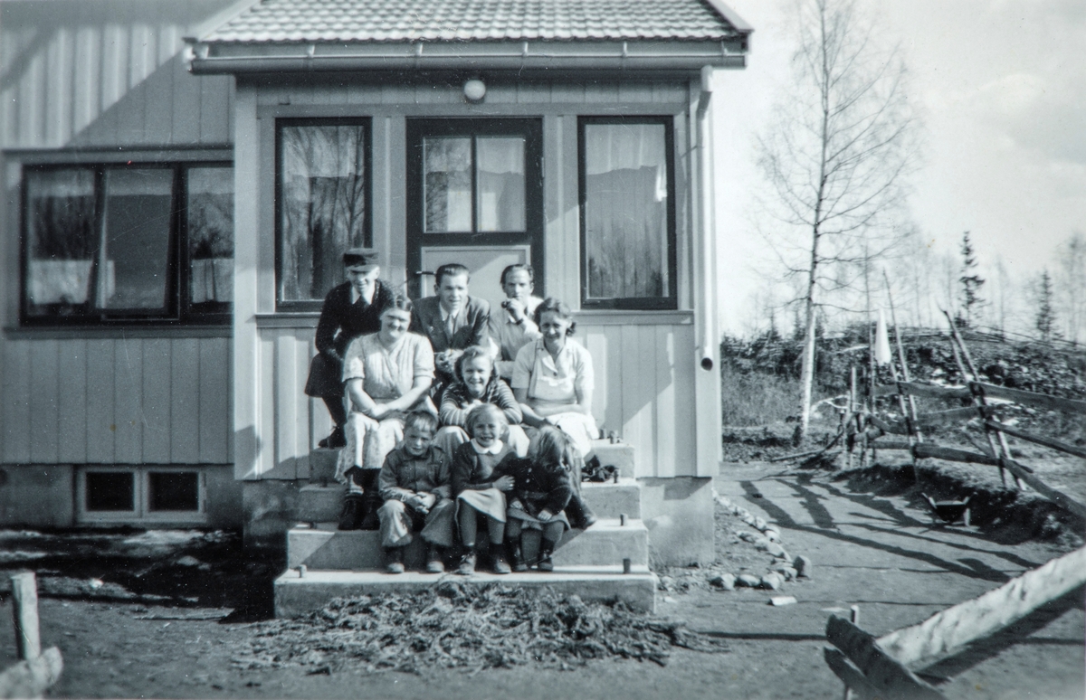 Gruppe 9 personer,
1. rekke: Arve Kristiansen, Gerd Kristiansen, ukjent. 
2. rekke Marie Andreassen, Petra Kristiansen, Palma Kristiansen. 
3. rekke Kristian Andreassen, Gunnar Pedersen, Gotfred Flatby. 
Bildet er tatt på trappa utenfor Saglund i Vang, 81/4.