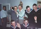 Bilden visar en grupp unga män dels i sjömanskostym dels i civila kläder som festar.