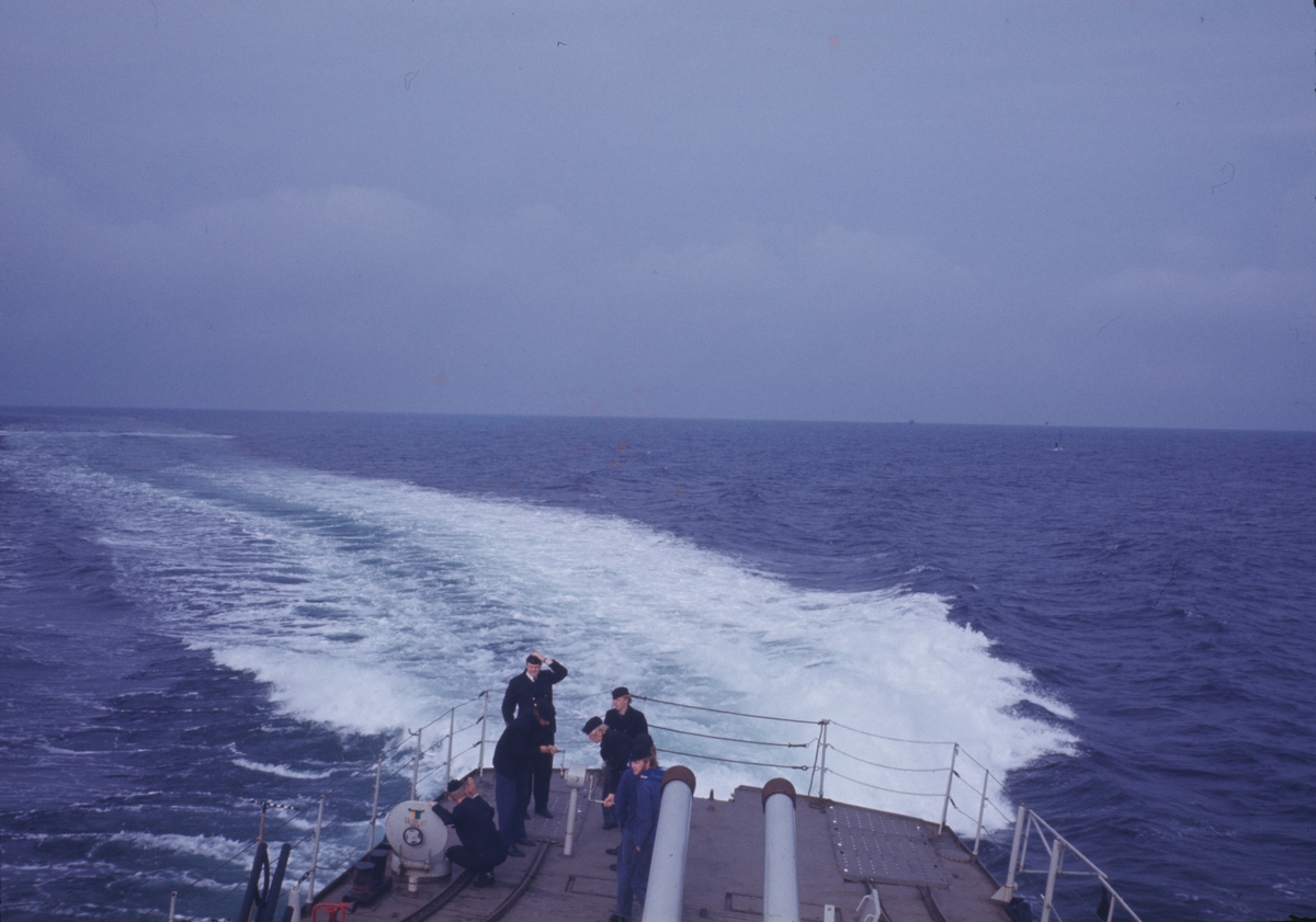 Bilden föreställer besättningsmedlemmar som arbetar på akterskeppet av jagaren Öland och medan den girar mot styrbord.