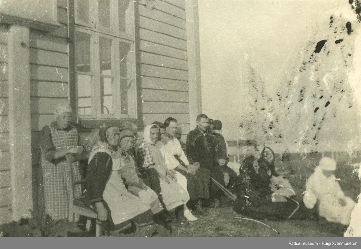 Eldre mennesker foran hus.