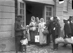 Svenskbybor vid förläggningen vid sin ankomst till Jönköping 1929. Från vänster står Kristoffer Andreasson Annas (f 1889) med sonen Oskar. Kristoffer återvände senare till Ryssland med sin familj. Maria Hoas (gift med Jakob Hoas) står med döttrarna Alma på armen och Alvina vid dörrposten. Maria Hoas född Knutas (1865-1943) står med kassar och paket i händerna. Hon är gift med Andreas Simonsson Hoas som står med persedelpåsen på axeln.