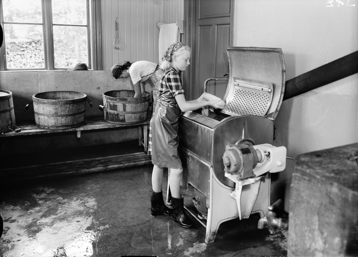 Två unga kvinnor i tvättstugan på Kumlans Lanthushållsskola, Uppland 1949