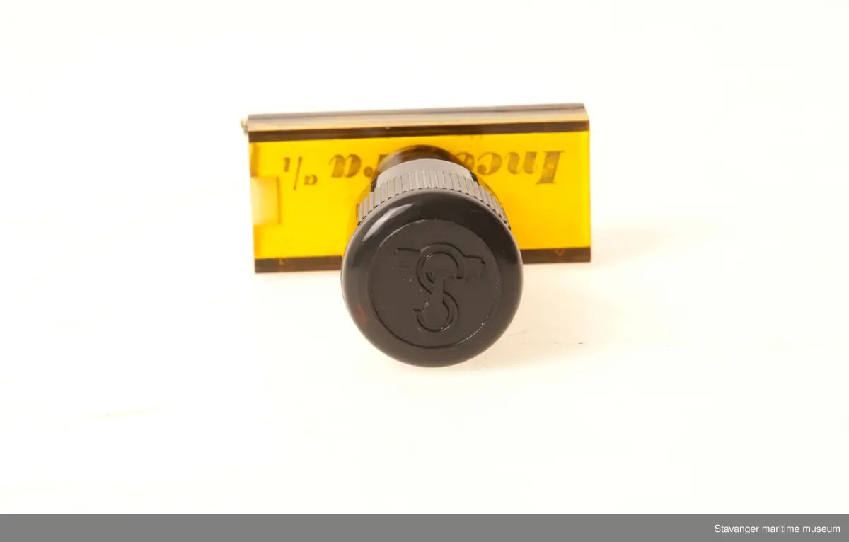 Stempel i plastikk og glass, hvor det står Incentra A/l Kontrakt med et øye over.