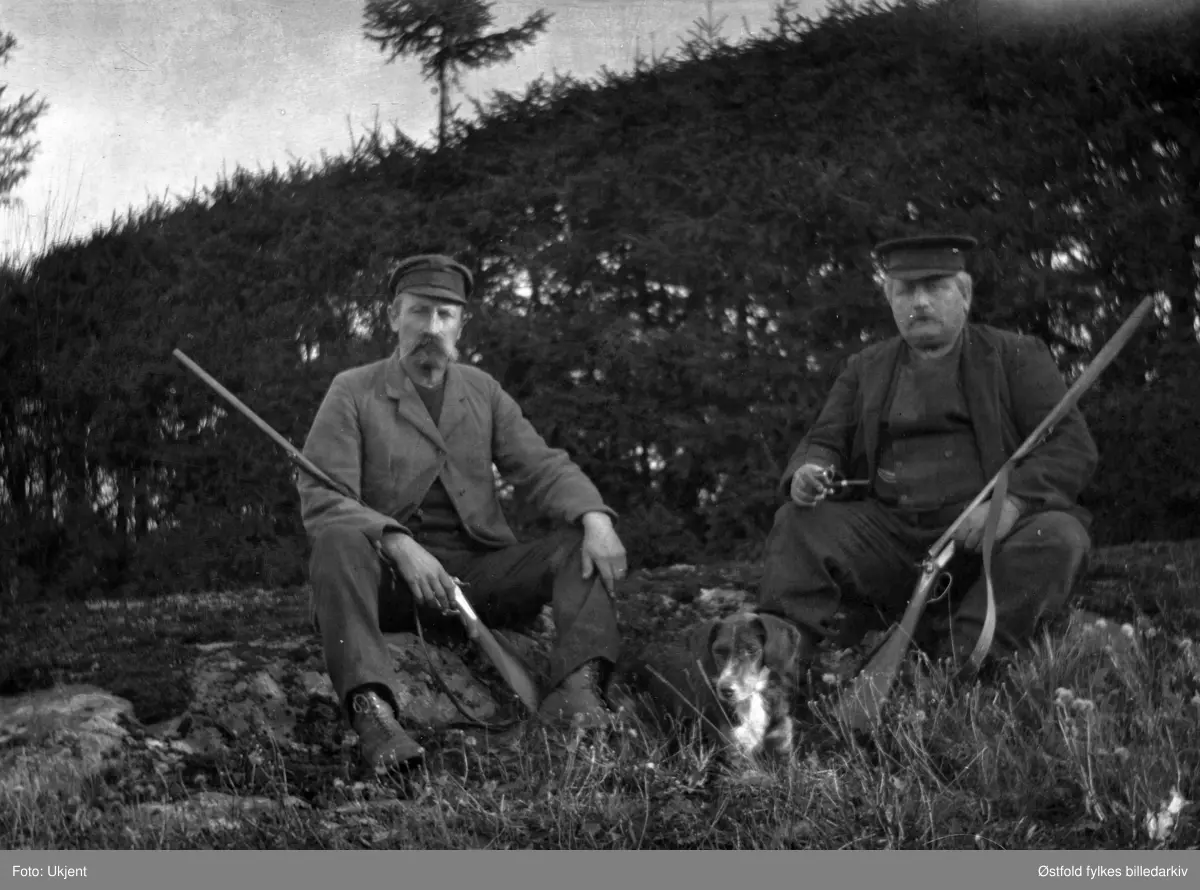 På jakt i Trøgstad ca. 1920. Jegerne er skomaker Nikolaisen og Hans Henningsmoen med hunden.