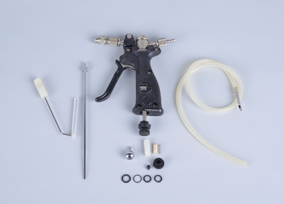 Vaksinepistol av merket Rapi-Vacc.
Automatisk multi-dose vaksinator. 
Hver dose er fra 0 - 1,0 ml
Med pistolen følger en tynn hvit gummislange med injeksjonsnål (?), Ventilasjonsrør (?) samt det som trolig er ulike reservedeler. 

Vedlagt brosjyre fra leverandøren og brev fra Proffesor Tore Håstein