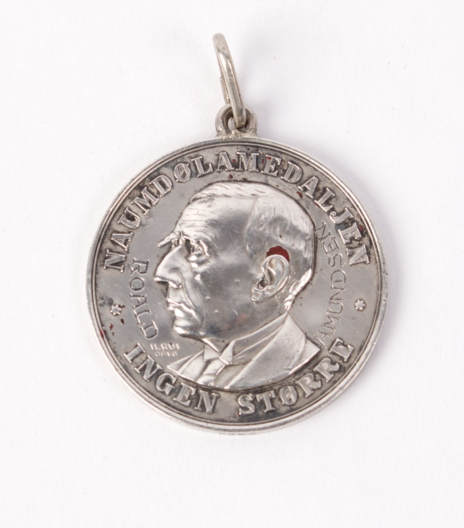 Motiv på forsiden er portrett av Roald Amundsen omkranset av tekst. Bakside kun tekst. 