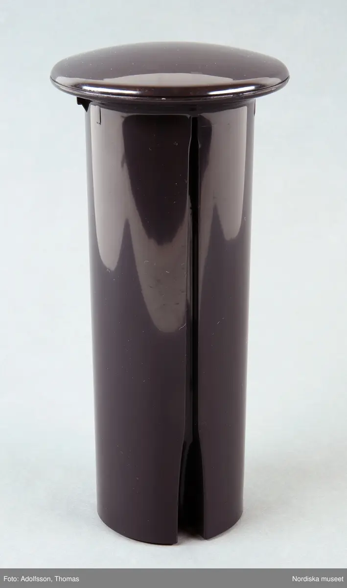 En elektrisk råsaftcentrifug av märket Elektrolux PERFECTJUICE ESF 2000. Består av  6 delar. a) Själva råsaftcentrifugen är cylinderformad och av metall och plast. De övriga delarna är av rökgrå hårdplast och består av b+) ett lock med c) press samt en d) behålllare som fruktköttet samlas i och e) en liten lockförsedd juicekanna med f) skumseparator i form av en plasskena som saften rinner ut i när den är klar. Dessutom en g) bruksanvisningsbroschyr och ett h) garantipapper.
Locket (b+) har en skada där en bit är avslagen.

Lena Kättström Höök 2014-01-10