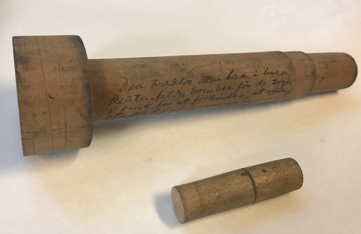 Geologiske prøver og bombedeler. Seks glassrør, en dreid trepropp og en liten beholder i tre. 

Trebeholderen inneholder tre små spisse pinner av ukjent materiale, muligens tennsatser. Et av de brune glassrørene inneholder små metallsylindre. Dette er trolig tennhetter .Et av rørene inneholder en liten glassbit, resten er tomme. Et av rørene er knust.