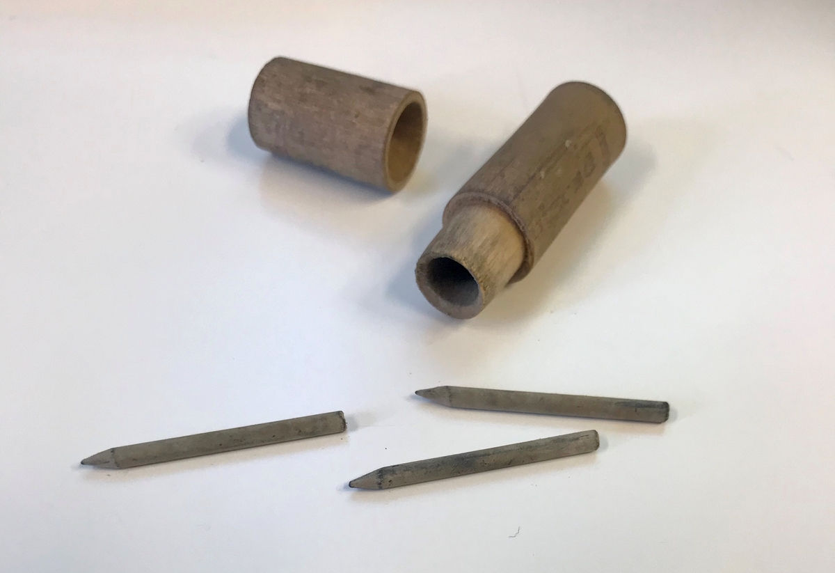 Geologiske prøver og bombedeler. Seks glassrør, en dreid trepropp og en liten beholder i tre. 

Trebeholderen inneholder tre små spisse pinner av ukjent materiale, muligens tennsatser. Et av de brune glassrørene inneholder små metallsylindre. Dette er trolig tennhetter .Et av rørene inneholder en liten glassbit, resten er tomme. Et av rørene er knust.