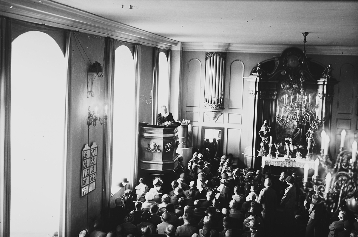 Prest på prekestolen, mennesker på kirkebenkene, Akershus slottskirke. Fotografert 1925.