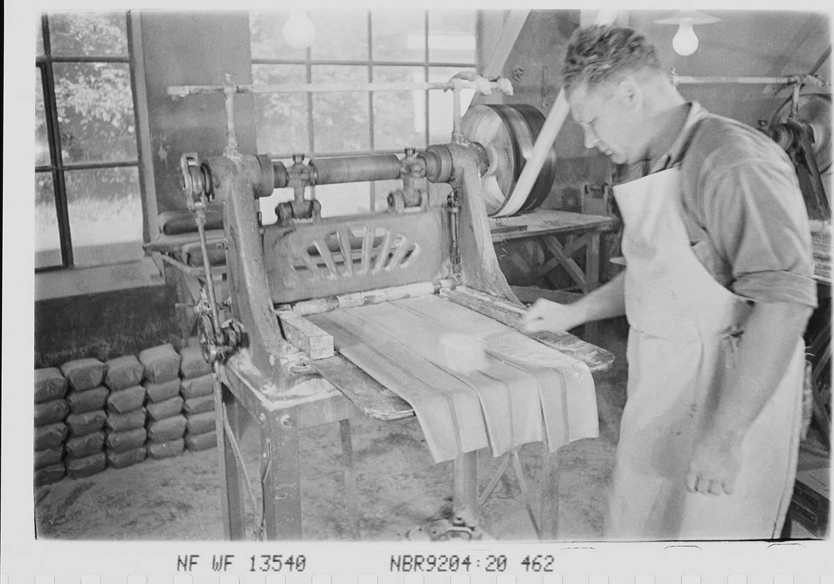 Ansatte i produksjonshallen. Den Norske Kalosje- & Gummivarefabrikk A/S, senere Mjøndalen Gummivarefabrikk, Eiker. Fotografert 1940.