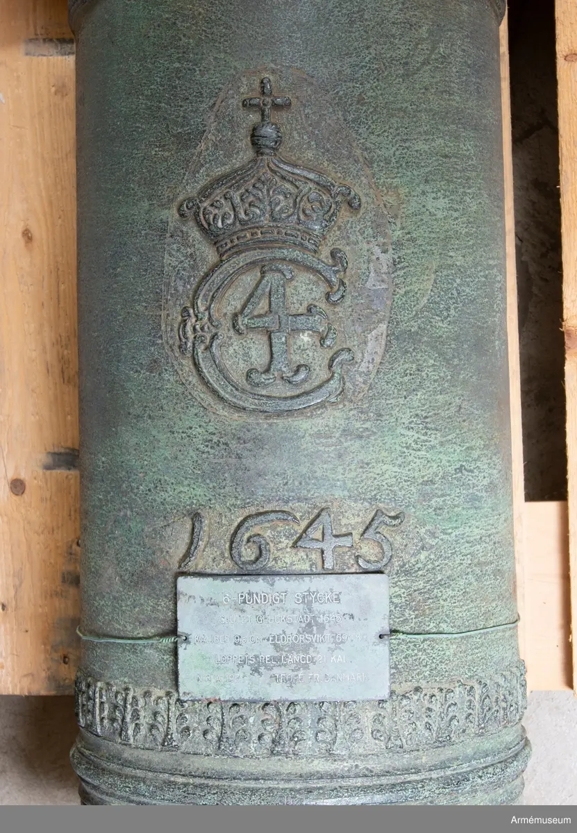 Grupp A I.
Med Kristian IV:s namnchiffer och därunder gjutåret 1645; å kammarbandet inskriften: FRANCISCUS. ROEN. ME. FECIT. GLYCKSTADT. (Frans Roen gjorde mig i Glückstadt) Loppets relativa längd: 21 kal.  Kaliber: 9,8 cm. Deuvhalsen märkt "4", vänster tapp märkt "1".
