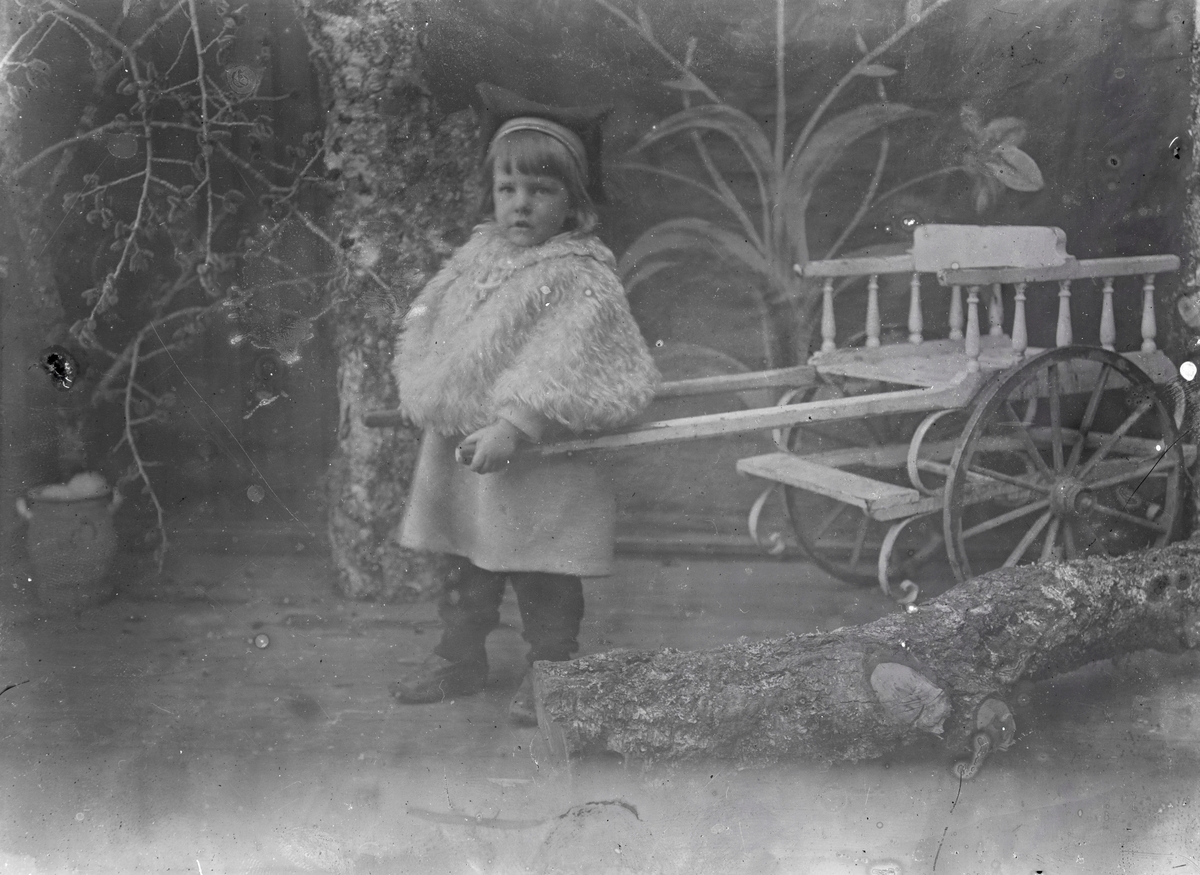 Portrett av en liten gutt i fotoatelier. Philip Aston Eikrem.