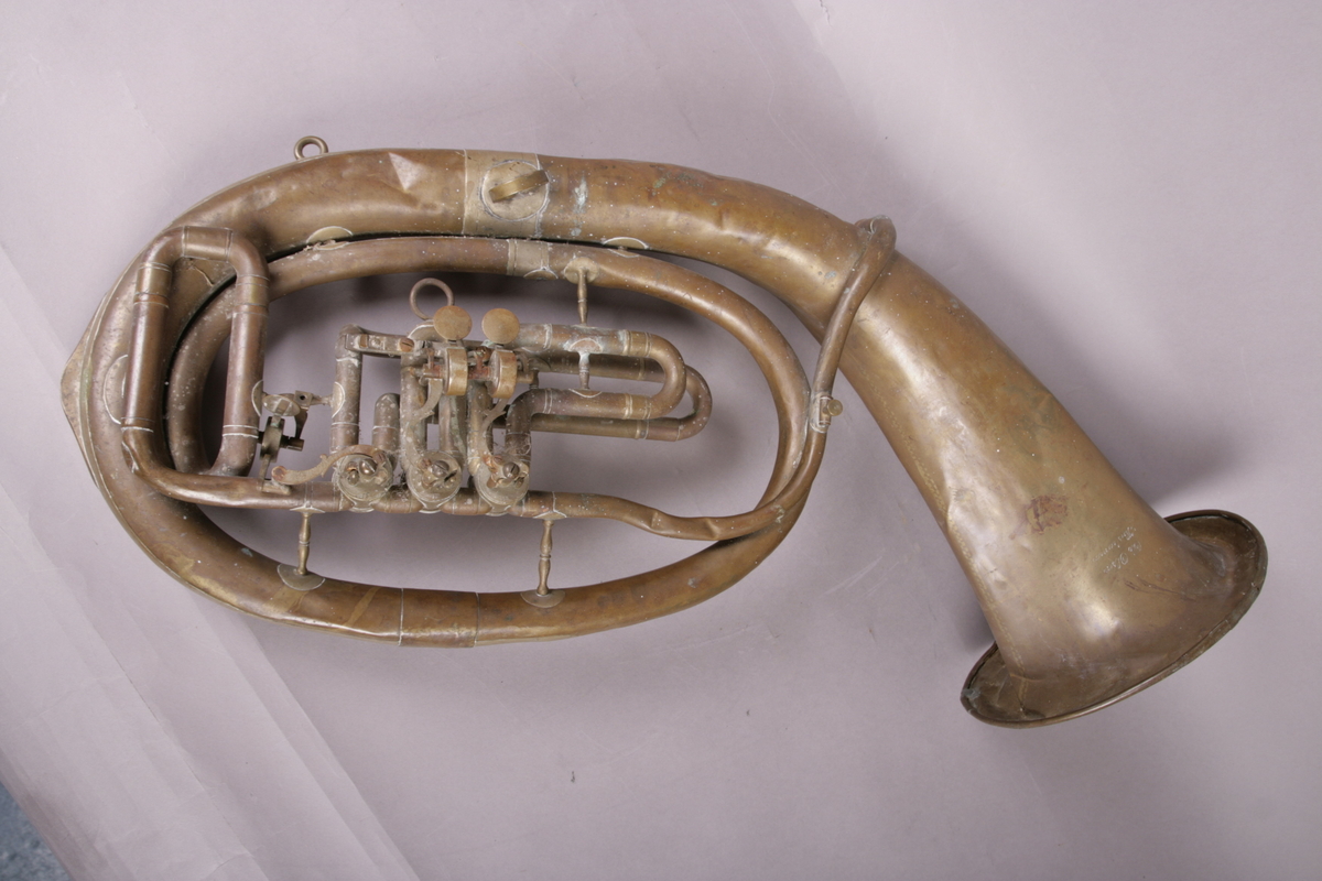 Blåseinstrument i metall med klaffer og ventiler.