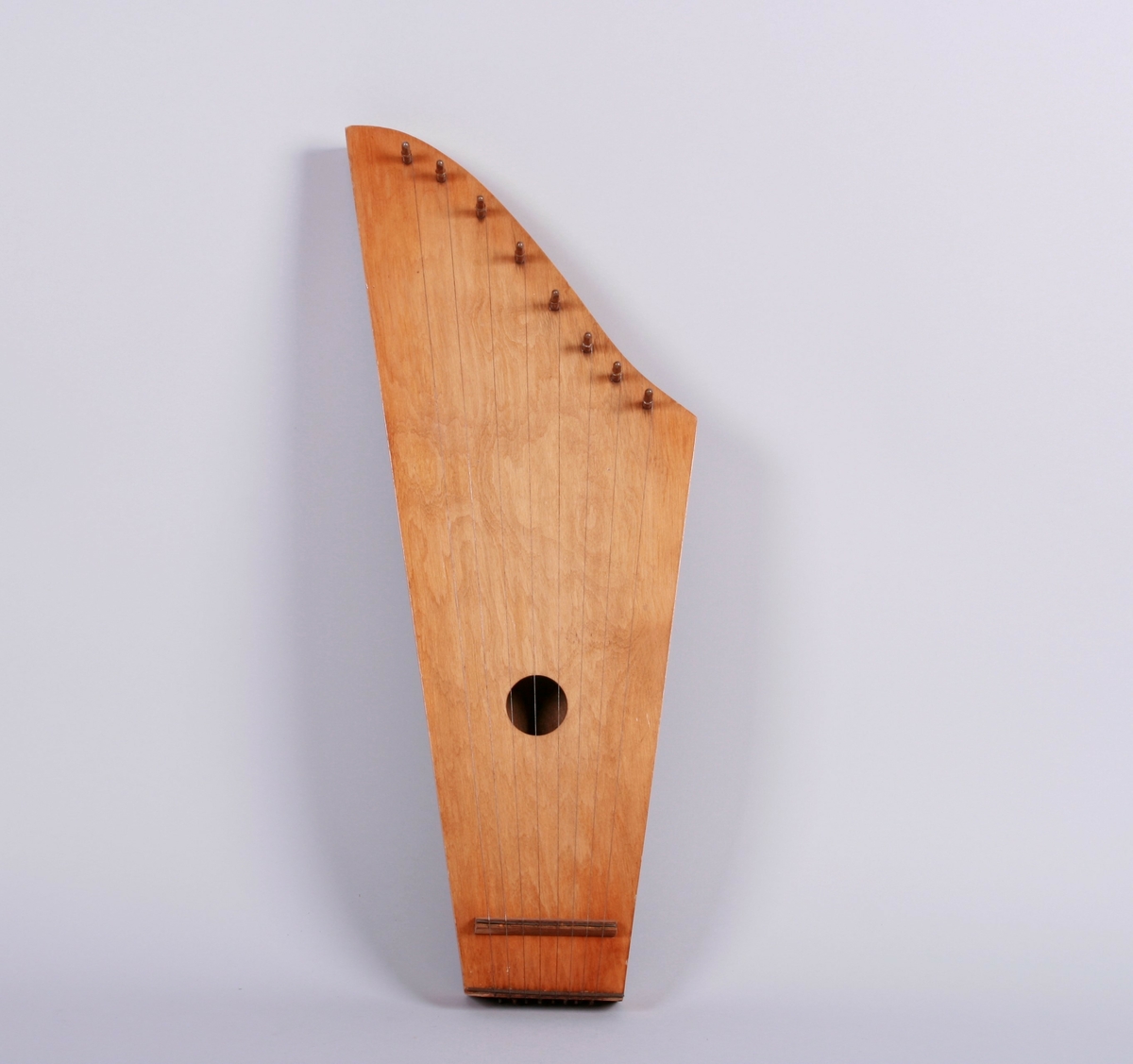 Kantele med åtte strenger. Rundt lydhull.