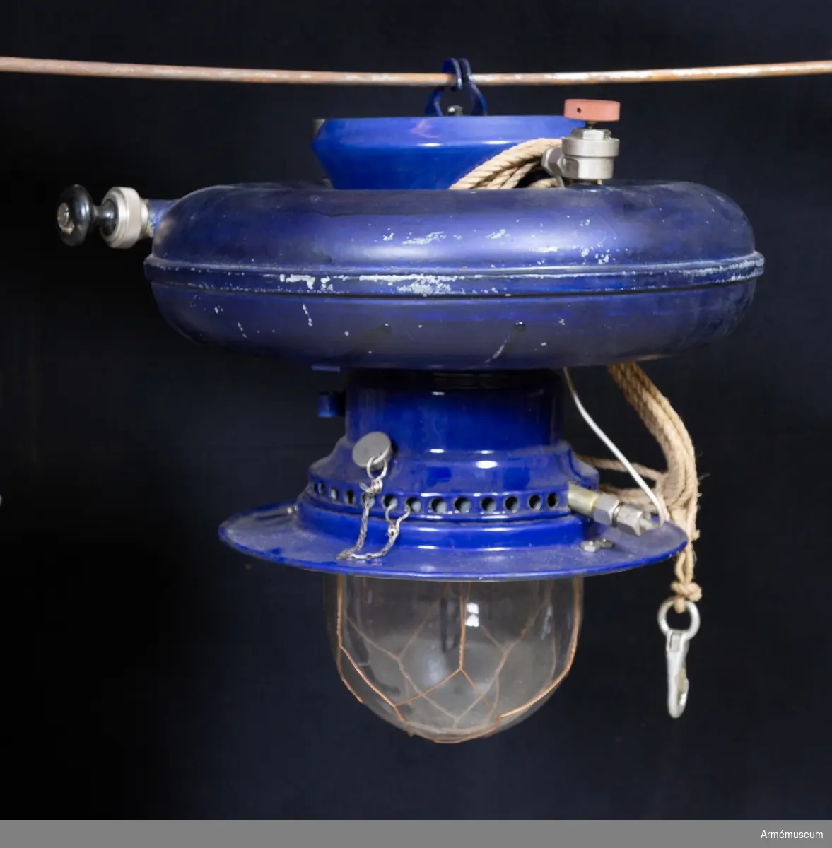 Grupp: I II. 

Lampa av typen Lux Inverella för 200-400 normalljus. Inom det militära avsedd för fältlasarett. Två fotogenkannor á 5 l saknas.