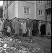 Folksamling med män och kvinnor på baksidan av Brahegatan 75a (Hjertströmska gården). Pastor Robert Svensson står med en spade för första spadtaget till Filadelfiakyrkan.