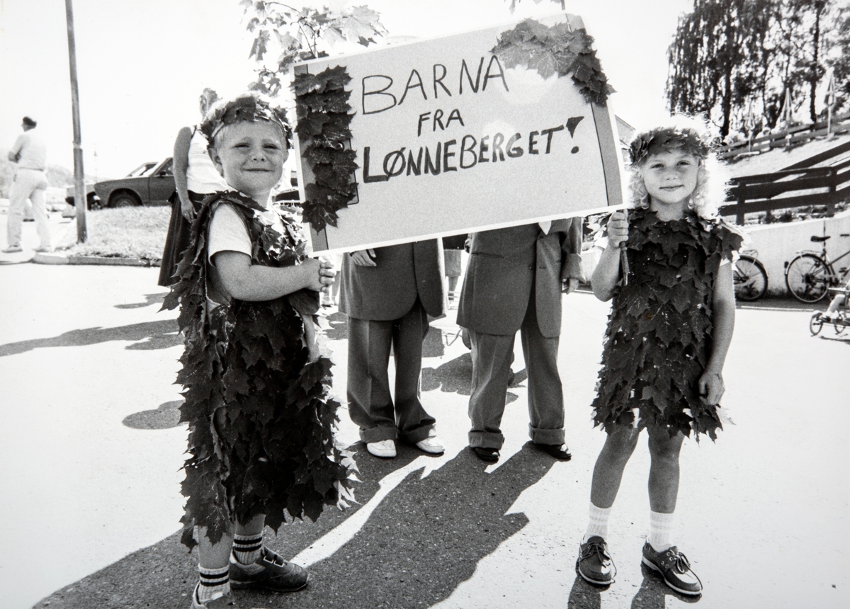 Barn, karneval. Barnekarneval.
Bilde fra barnekarnevalet på Dalamarten i 1988. Karianne Berg og Stig Sveen i sine herlige kostymer, vant førstepremien i konkurransen. Marit Elvsvebakken var dagmamma til begge barna, hadde laget kostymene ved å lime et utall lønneblader på tøyet. Som en ser, temaet ble da selvfølgelig Lønneberget, Dalamarten har blitt arrangert fra 1970-tallet.