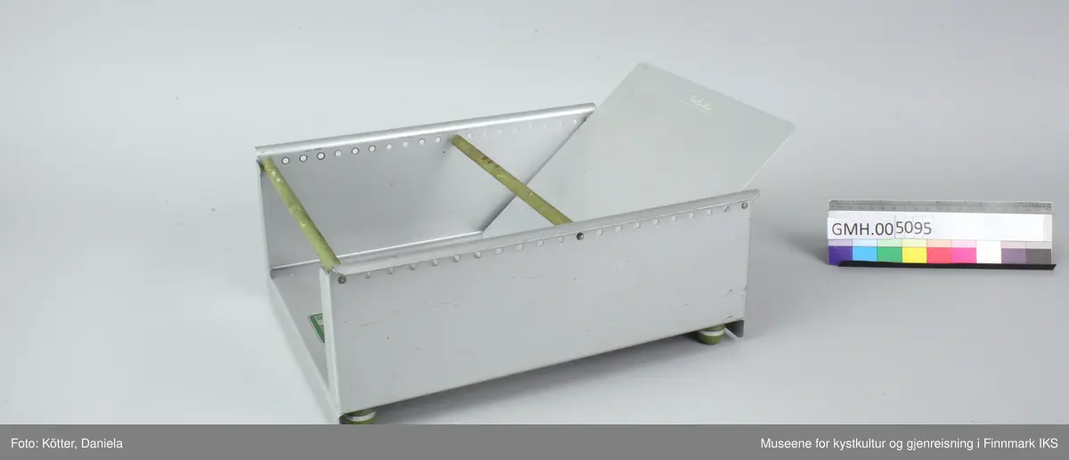 Trauet har en bunn og to sider av aluminium. Sidene er foran og bak forbundet med stenger. Imellom er det en stang som kan flyttes Det følger også med en skillevegg som kan settes i slisser i bunnen.
