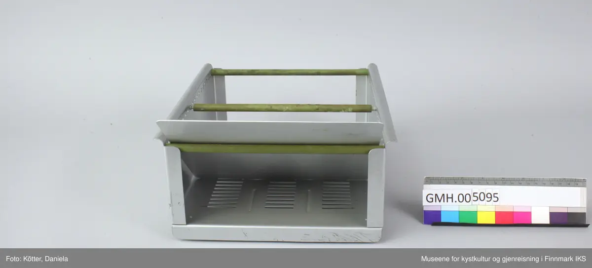 Trauet har en bunn og to sider av aluminium. Sidene er foran og bak forbundet med stenger. Imellom er det en stang som kan flyttes Det følger også med en skillevegg som kan settes i slisser i bunnen.