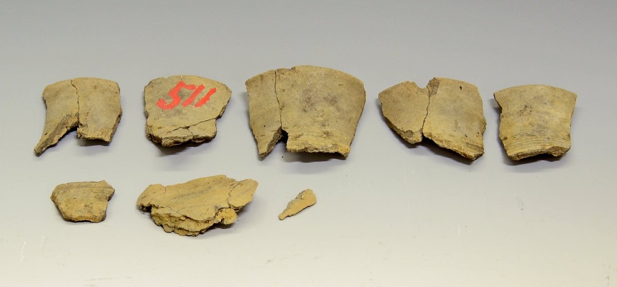 Fra protokollen: 
her foreligger ennå et leirkar (under SM.0511), et lite beger i fragmenter, noe nær Bøe: Jernalderens keramikk, fig. 188. Hverken form eller dekor kan bestemmes nærmere ut ifra de små bitene som foreligger. Feilnummerering, dette kar hører vel neppe til resten av funnet, dog kan det passe inn i tid. Yngre romertid, 4. årh.