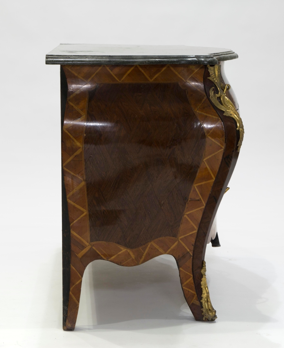 Intarsia  formet som et skjold med krone, og sammenflettede blomstergrener på skjoldet.