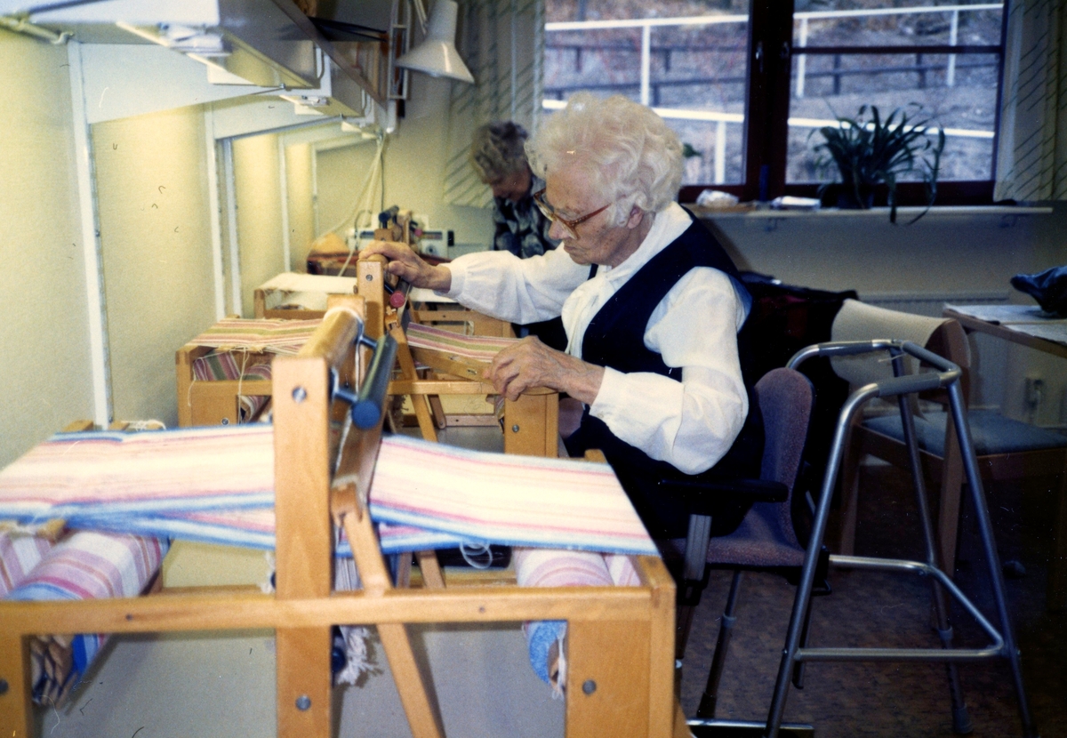 Alida Ekström (1896 - 1994, född Karlsson) sitter och väver i Brattåsgårdens hobbylokal, okänt årtal. Alida föddes på gården Hallen i Kållered.