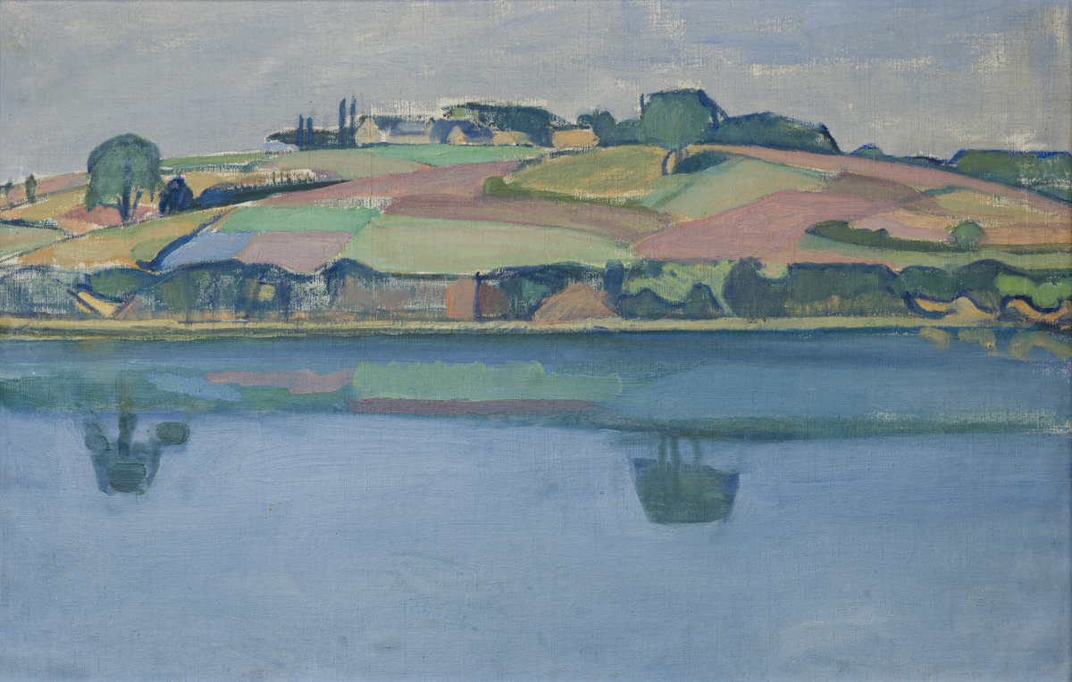 Blått vann i forgrunnen med landskap med sletter i bakgrunnen. Landskapet speiler seg i vannet. 