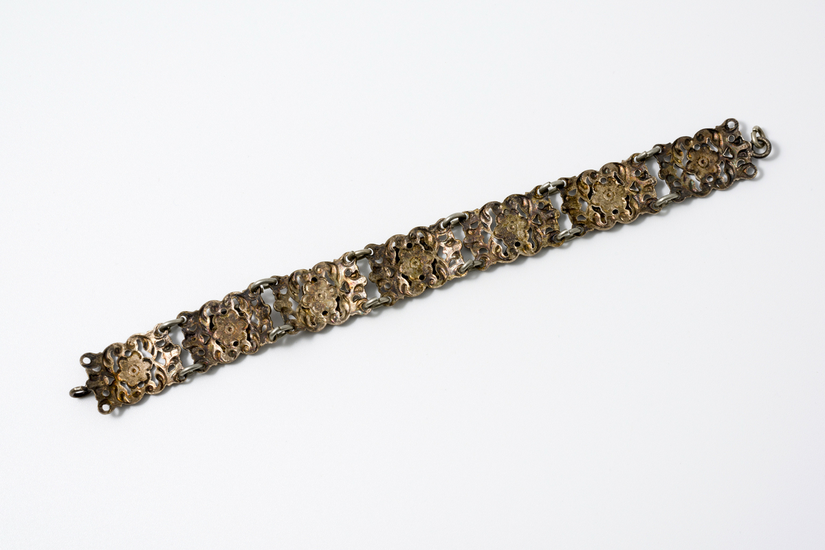 Armbånd i metall dekorert med motiv av blomster og kulturminner/landemerker (f.eks. eiffeltårnet og triumfbuen)
