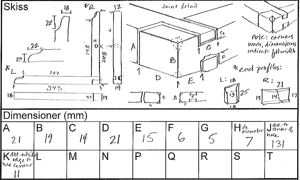 En vinkelhake.

Vinkelhaken består av två plana stavar som är sammanfogade genom sinkning. Ändarna är profilerade. I mitten av den kortare staven finns ett runt hål för upphängning.

Vinkelhaken är välbevarad och i gott skick.

För mer information se Dokumentationsblankett under Referenser – Länkade filer.