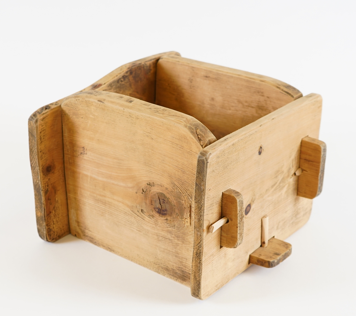 Smørform i tre. To av sidene, samt botnen, har utstikkarar på sidene, medan dei to andre har hol. Forma vert sett saman til ei kasse ved å setje utstikkarane inni hola. Gjennom utstikkarane er det sett i trepluggar, for sikring.