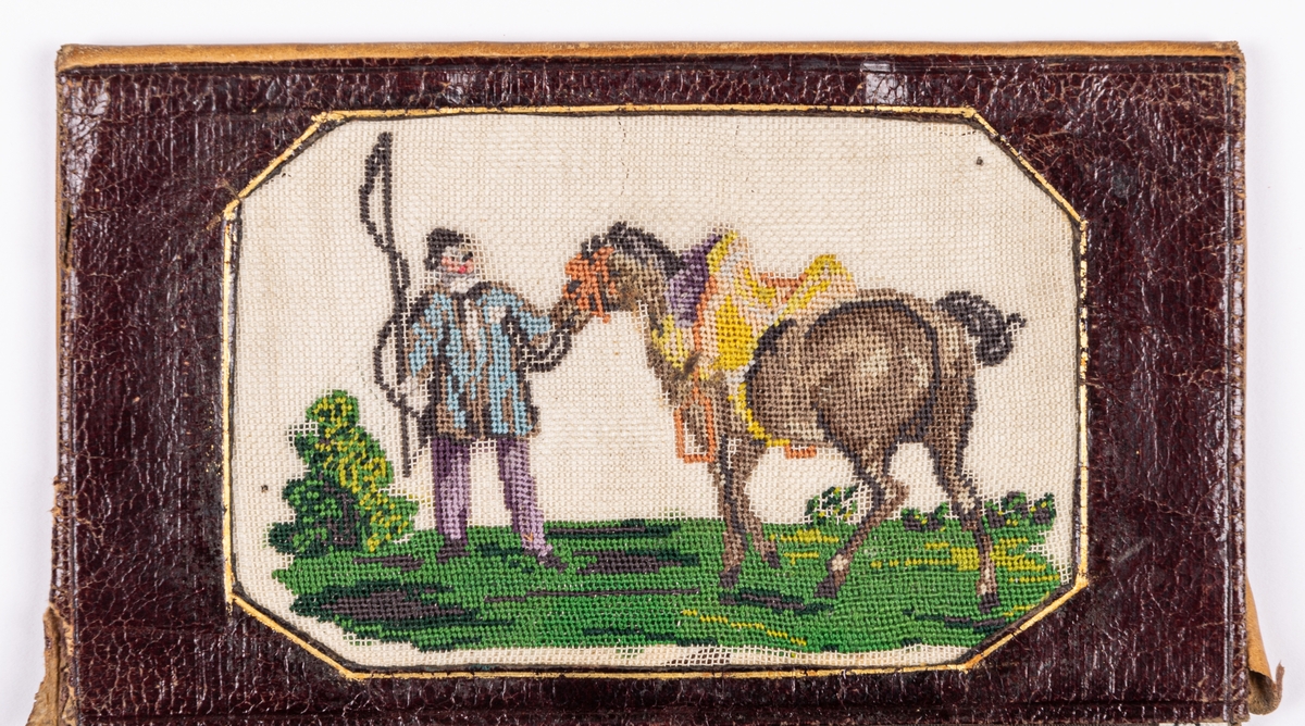 Plånbok av kalvskinn. Inuti broderier i petit-point.