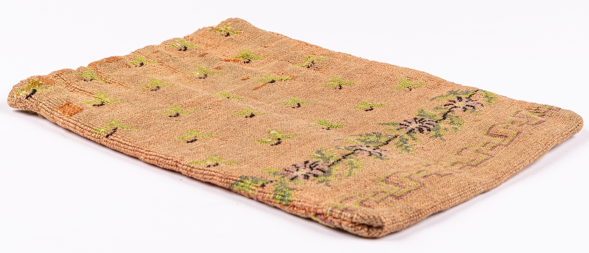 Väska, korsstygnsbroderi i gammalrosa, små blommor och blad strödda, nedtill en ranka i grönt och lila: blommor och blad, nederst en á la greque i grönt och lilka, grönt foder.