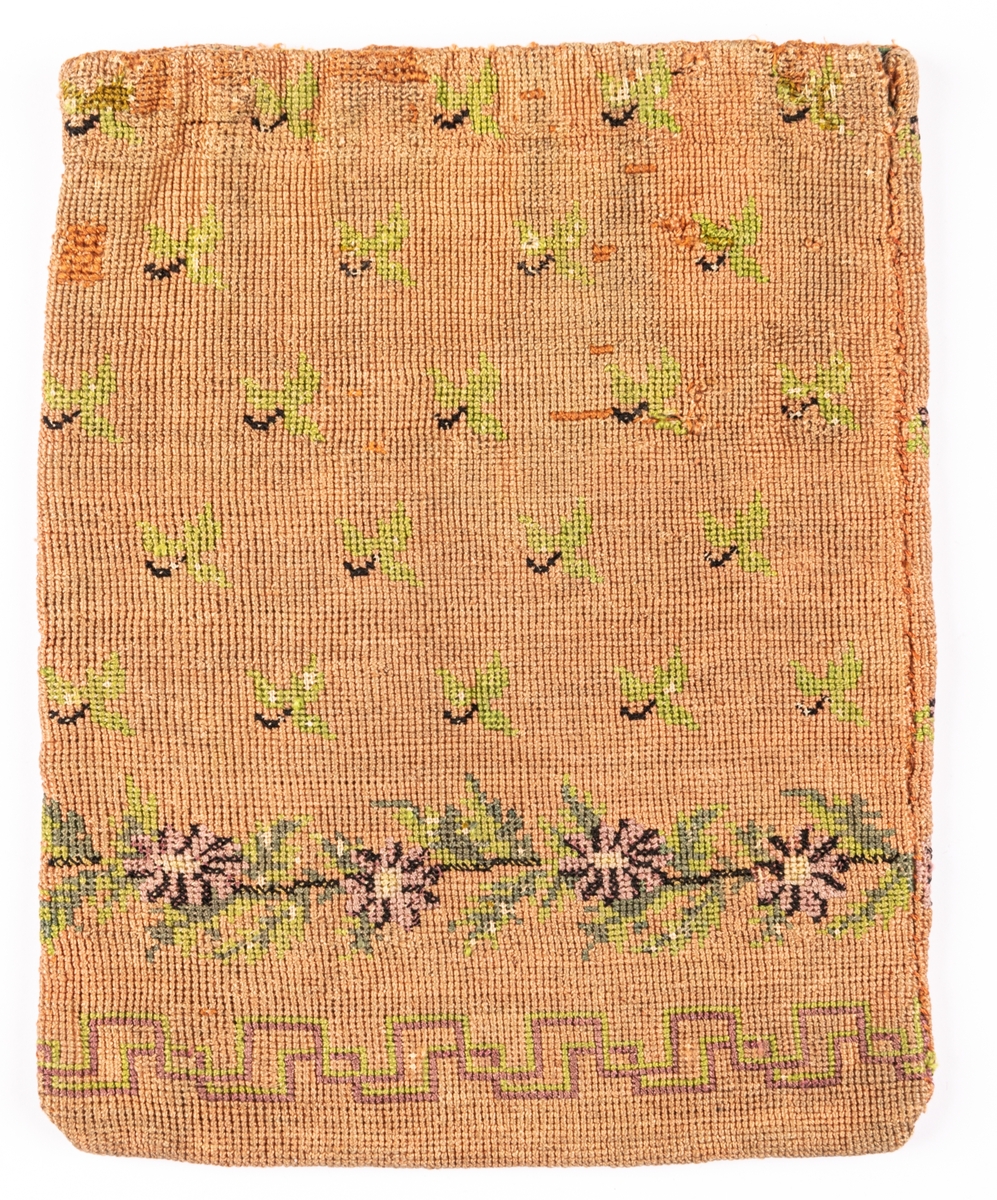 Väska, korsstygnsbroderi i gammalrosa, små blommor och blad strödda, nedtill en ranka i grönt och lila: blommor och blad, nederst en á la greque i grönt och lilka, grönt foder.