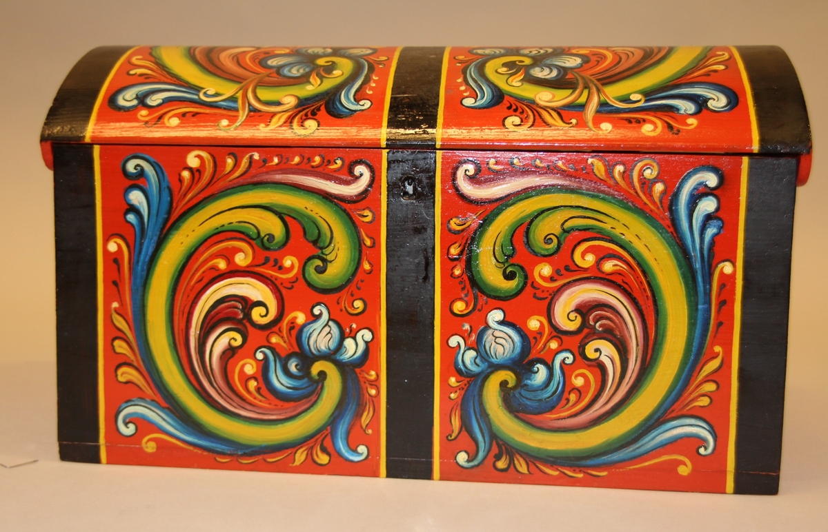 Rosemåla. lita kiste i klare fargar. Tydlege C-krullar både på loket og framme, desse er ramma inn med svarte, måla band.Raud botnfarge. Einsfarga sider og bakside. Umåla under botn. På Baksida er det måla DALEN.  Inni har kista eit lite rom på den eine sida. Grønmåla inni. Kuva lok. Lås med nøkkel.