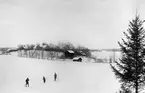 Bröderna Hallin åker skidor i snön. I bakgrunden skymtar hemmet Ramsdal beläget i Sankt Anna socken.