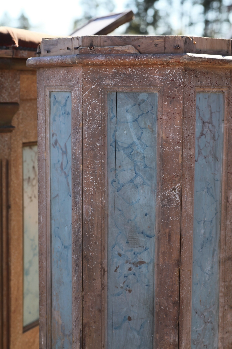 Prekestol (a), fot (b) og (c og d) et dekorelement formet som en flamme, fra Aas kirke, Bøverbru. Sekskantet prekestol med en innebygget plate for å plassere bibelen langs framsiden. Hver side har speil som er blåmalt i marmoreringsteknikk, mens resten av hver vegg er malt rosa med prikker i dekorasjonsmaling som imiterer en annen steintype. Påskrift nede på prekestolen: "Uttatt 1915 fra Aas Bøverbru". Antatt tatt ut fra Aas kirke i forbindelse med brannen i 1915.