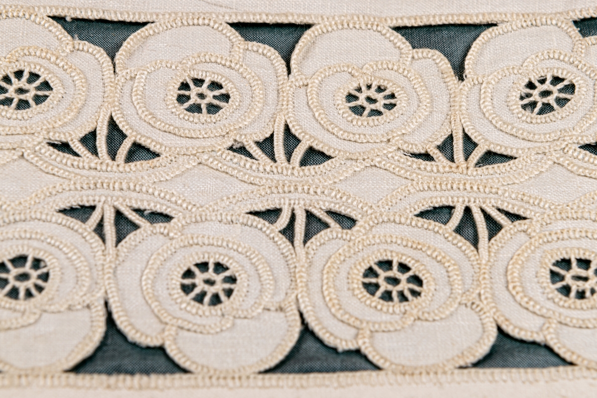 Servettväska i vitt linne med venetianskt broderi. Fodrad med grönt råsiden.