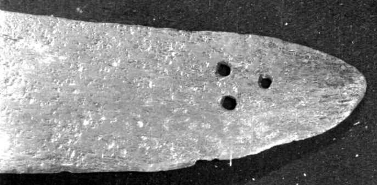 Rund tønneformet knapp i tre. Asymmetrisk feste med tre sidebøyler som har fortykninger på midten på utsiden og tommelbøyle og to sidebøyler på innsiden. Nyreformede parérplater. S-formede runde parérstenger med fortykkede avslutninger på endene. Fremre parérstang er nyere.
Tregrep med jerntrådvikling.
Enegget krum kline med smal ryggstillt blodrand. Smedmerke på venstre side. Klingespissen er dekorert med tre små hull.