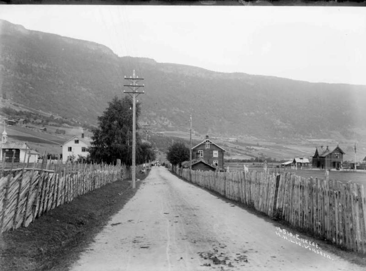 02.08.1909. Kvam med garden Klevstad til venstre, i midten Klevstadvolden der det var butikk og til høyre Kvam stasjon